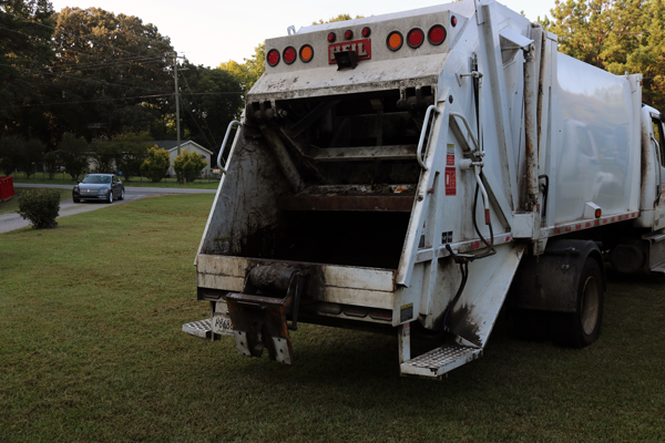 Garbage truck with red dumpster for commercial service